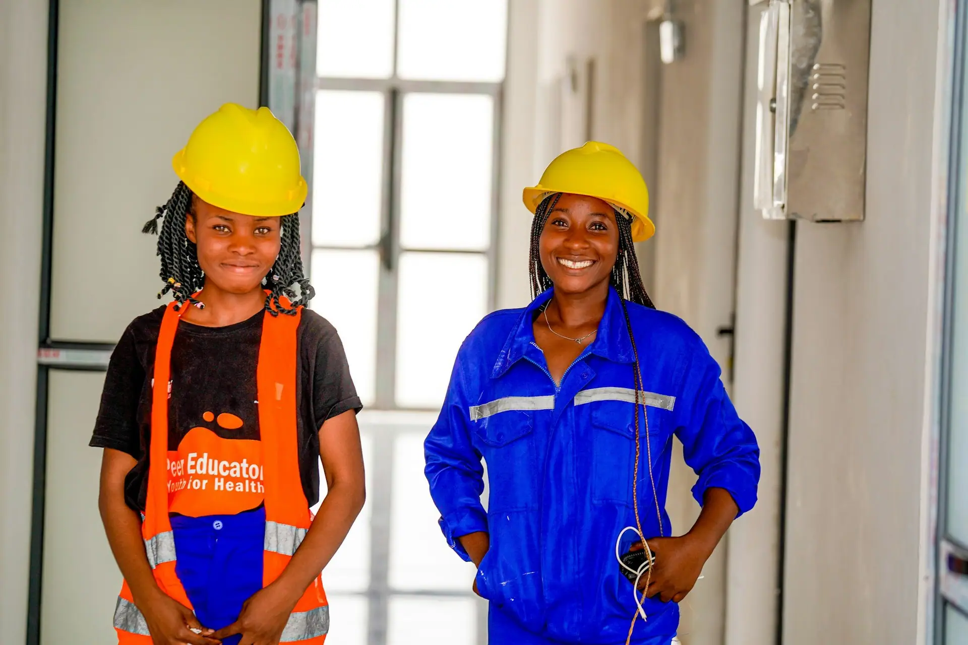 Two engineers in hard hats and workwear smiling