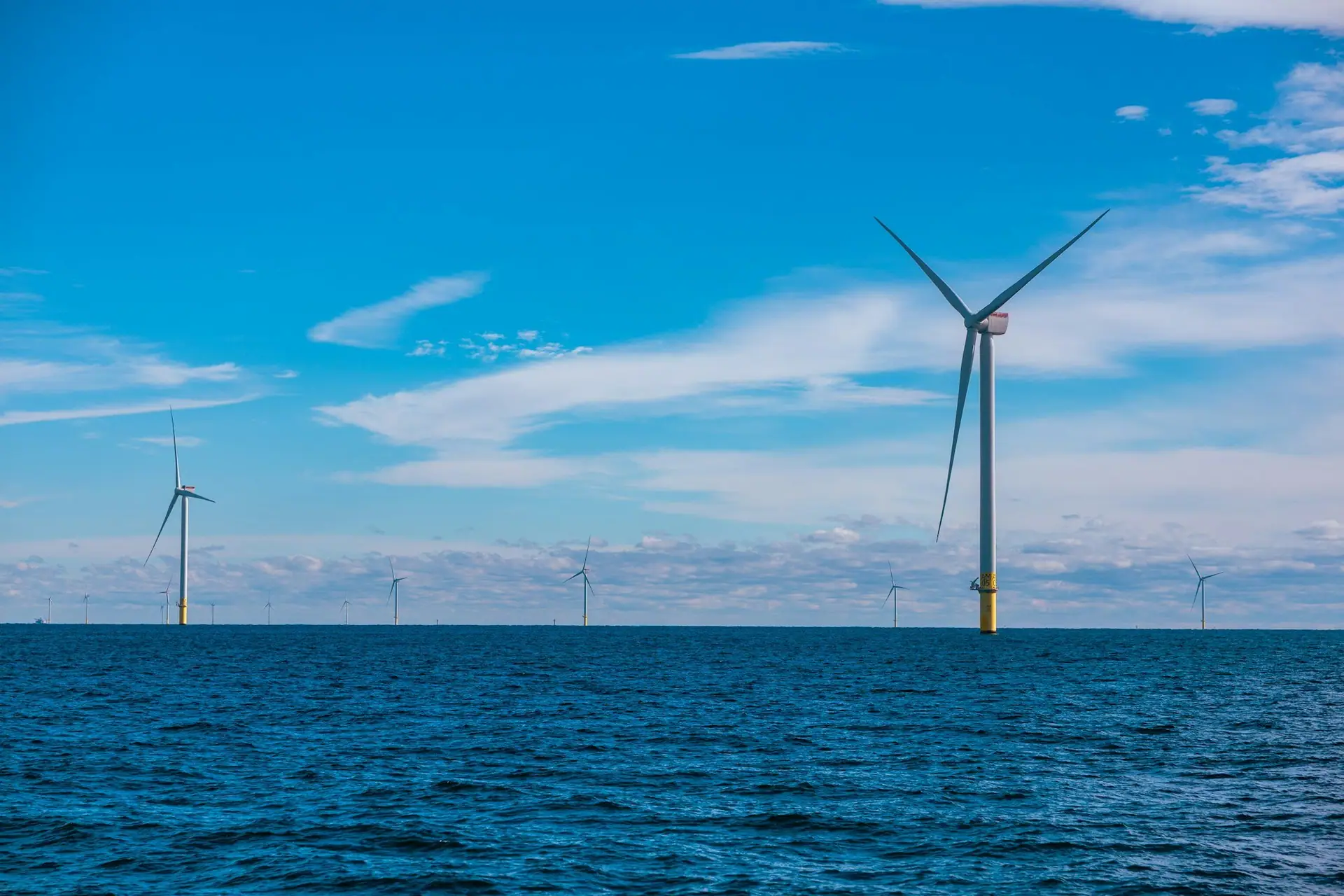 Line of offshore wind turbines stretching to the horizon