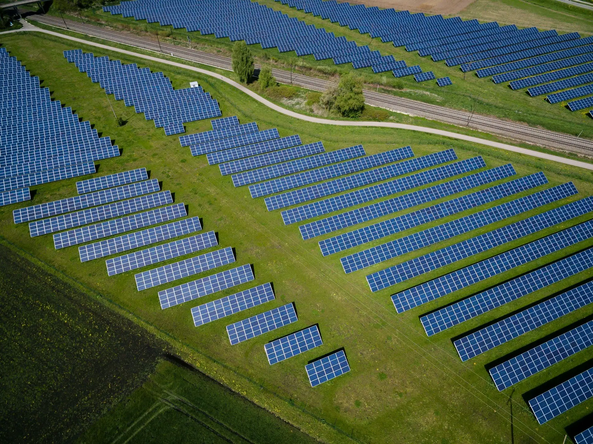 Aerial view of a large solar farm laid out in rows across grassland